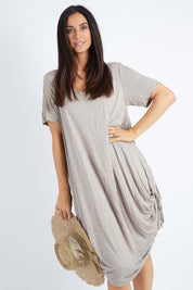Model Gemma wearing size S-M of the Primrose Dress in colour Oatmeal, from the front, cropped image