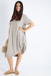 Model Gemma wearing size S-M of the Primrose Dress in colour Oatmeal, from the front, showing the whole outfit