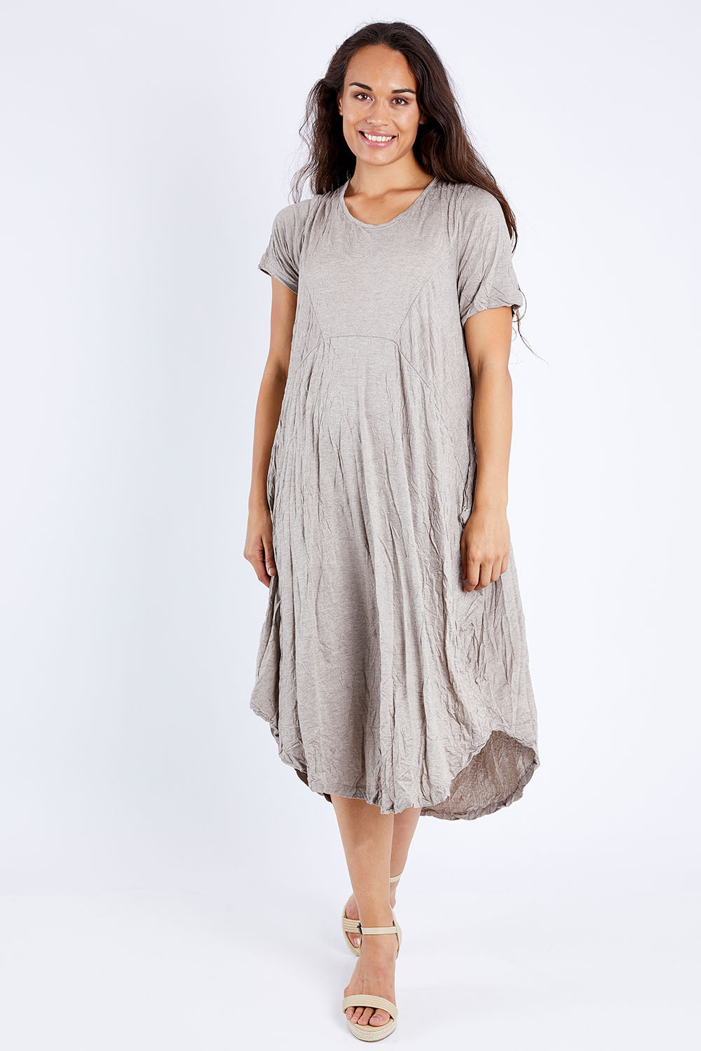 Model Larissa wearing size S-M of the In Bloom Flowing Dress in colour Oatmeal, from the front, showing the whole outfit