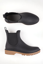 A model wearing size 37 of the Laurina2 Gumboot in colour Black (Black), from the front, showing the whole outfit