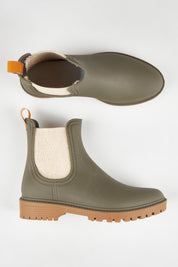 A model wearing size 37 of the Laurina2 Gumboot in colour Olive (Green), from the front, showing the whole outfit