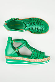 A model wearing size 37 of the Accra Leather Sandal in colour Emerald (Green), from the front, showing the whole outfit