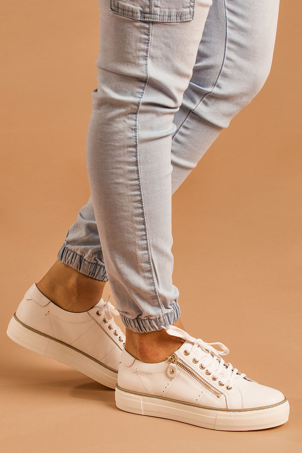 A model wearing size 37 of the Froggy Leather Sneaker in colour Whiteleath (White), from the front, cropped image