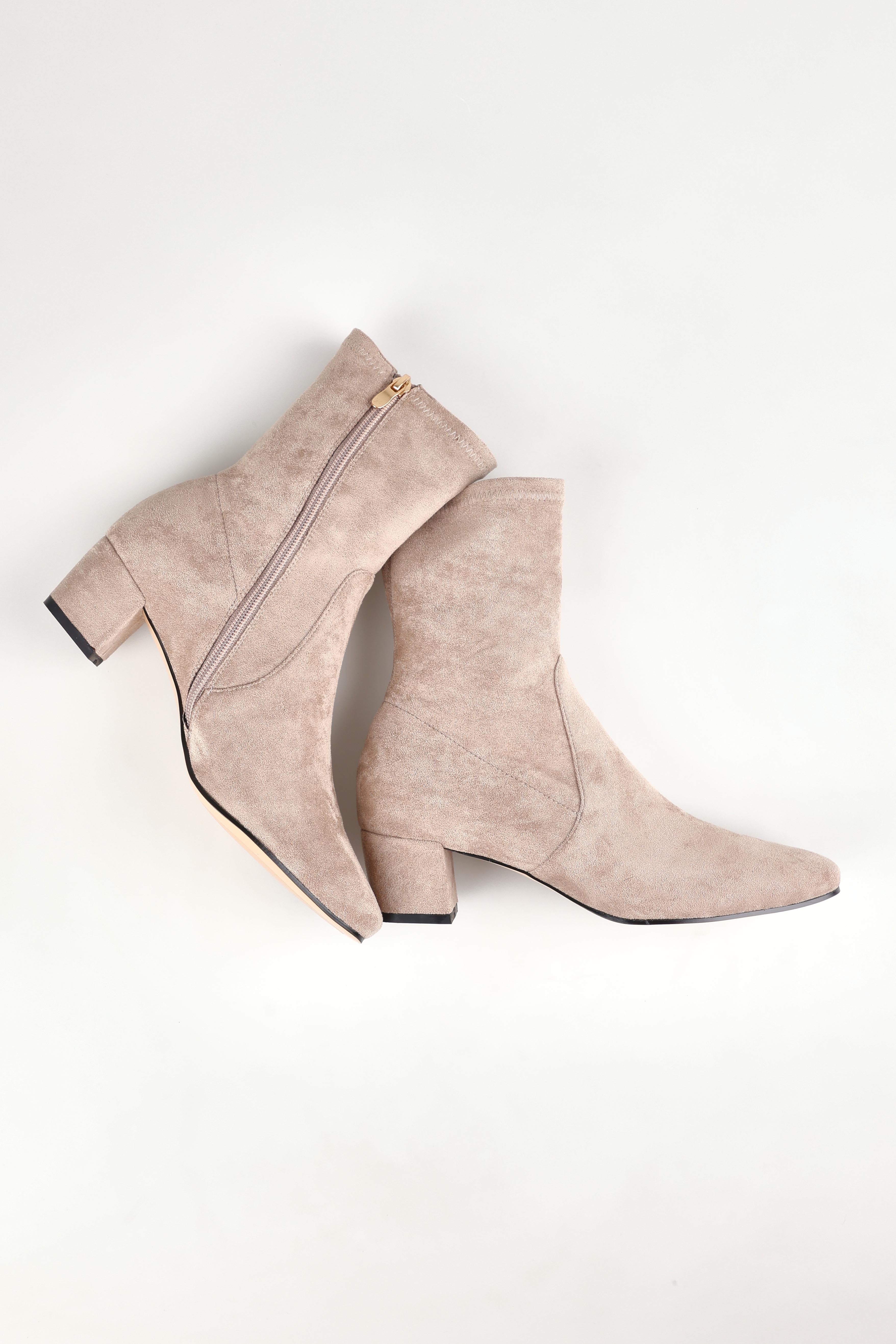 A model wearing size 37 of the Hartful Stretch Ankle Boot in colour Taupemicro, from the front, showing the whole outfit