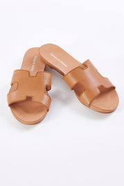 A model wearing size 37 of the Jamel Leather Flat Sandal in colour Darktan, from the front, showing the whole outfit