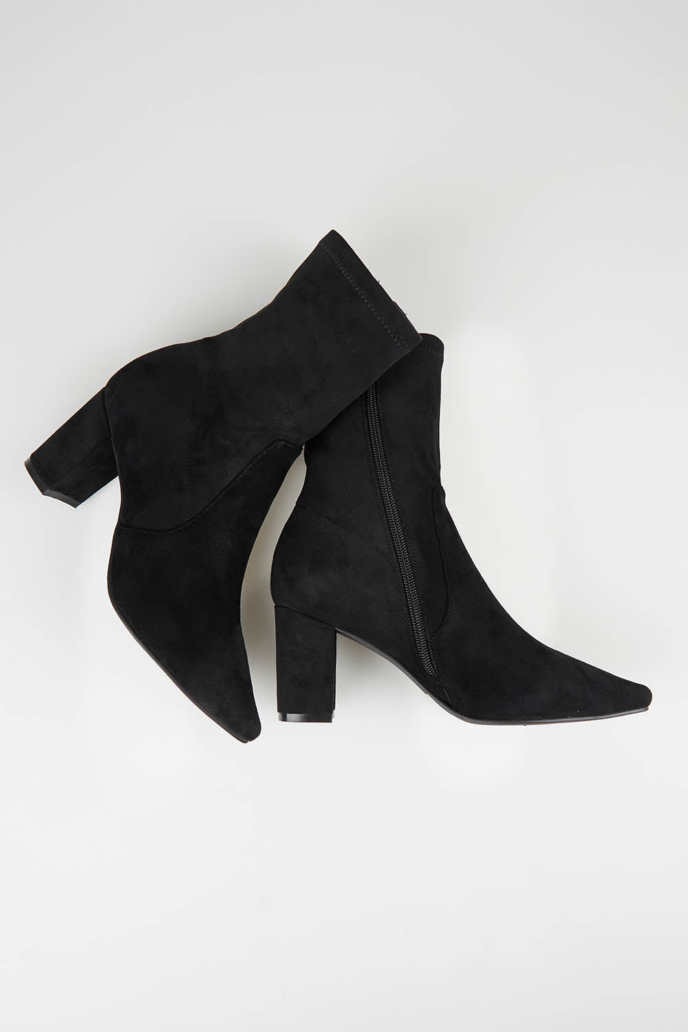 A model wearing size 37 of the Nider Stretch Heel Ankle Boot in colour Blackstret (Black), from the front, showing the whole outfit