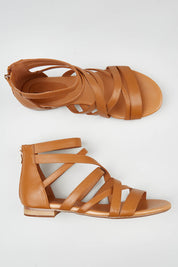 A model wearing size 37 of the Pillish Leather Flat Sandal in colour Tan, from the front, showing the whole outfit