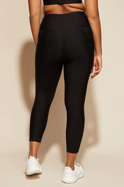 A model wearing the Elite Tight 7/8 in colour Black (Black), from the back