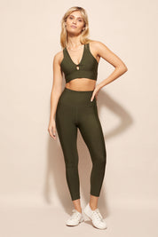 A model wearing the Match Point Tight in colour Khaki (Green), from the front, showing the whole outfit
