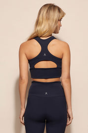 A model wearing the Zuki Ribbed Crop in colour Navy (Blue), from the back
