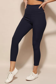 A model wearing the Harlow Ribbed Tight in colour Navy (Blue), from the front, cropped image