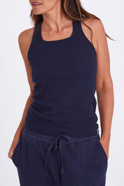 Model Alex wearing the Tempo Tank in colour Navy (Blue), from the front, cropped image