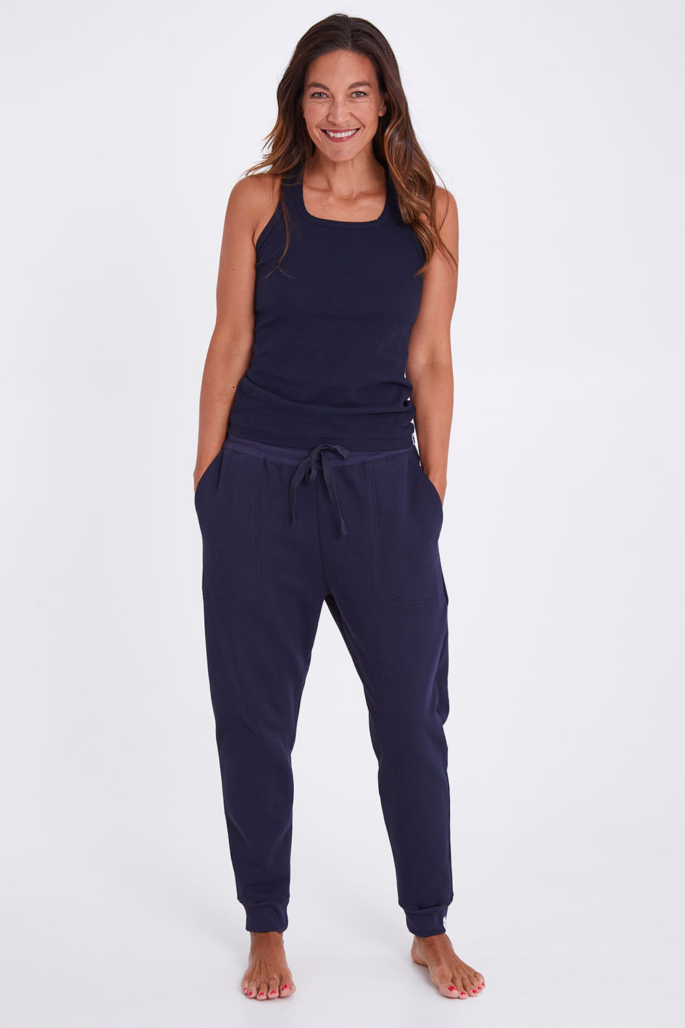 Model Alex wearing the Tempo Tank in colour Navy (Blue), from the front, showing the whole outfit