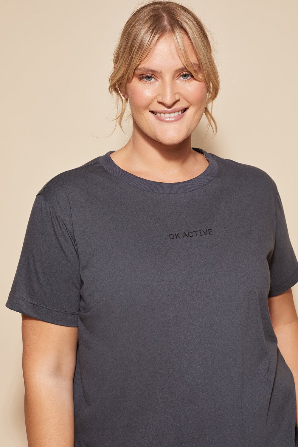 A model wearing the Way Back Tee in colour Smoke (Grey), from the front, cropped image