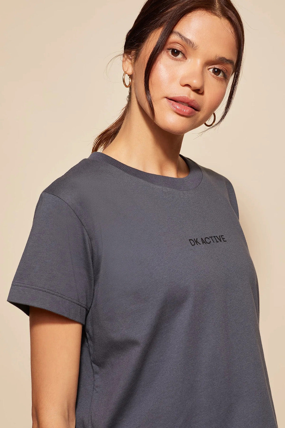 A model wearing the Way Back Tee in colour Smoke (Grey), from the front, cropped image