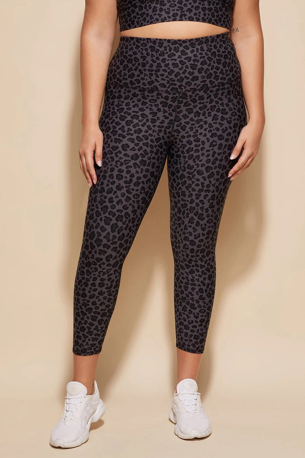 A model wearing the Utopia Tight in colour Leopardsmk (Grey), from the front, cropped image