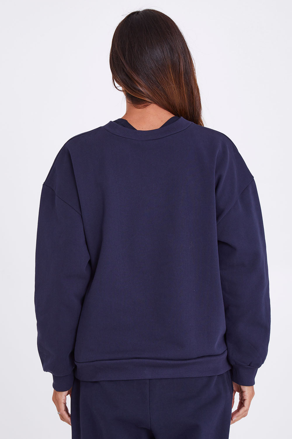 Model Alex wearing the Sonny Jumper in colour Navy (Blue), from the back