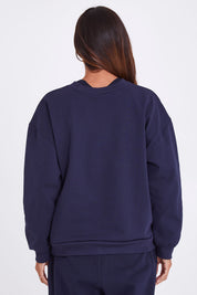 Model Alex wearing the Sonny Jumper in colour Navy (Blue), from the back