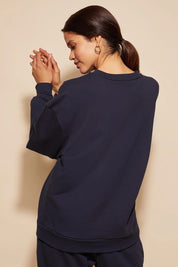 A model wearing the Sonny Jumper in colour Navy (Blue), from the back
