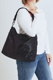 Model Steph wearing the Adele Large Leather Bag in colour Black (Black), from the front, cropped image