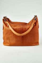 A model wearing the Adele Large Leather Bag in colour Tan, from the front, showing the whole outfit