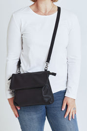Model Steph wearing size OneSize of the Delphi Leather Bag in colour Black (Black), from the front, cropped image