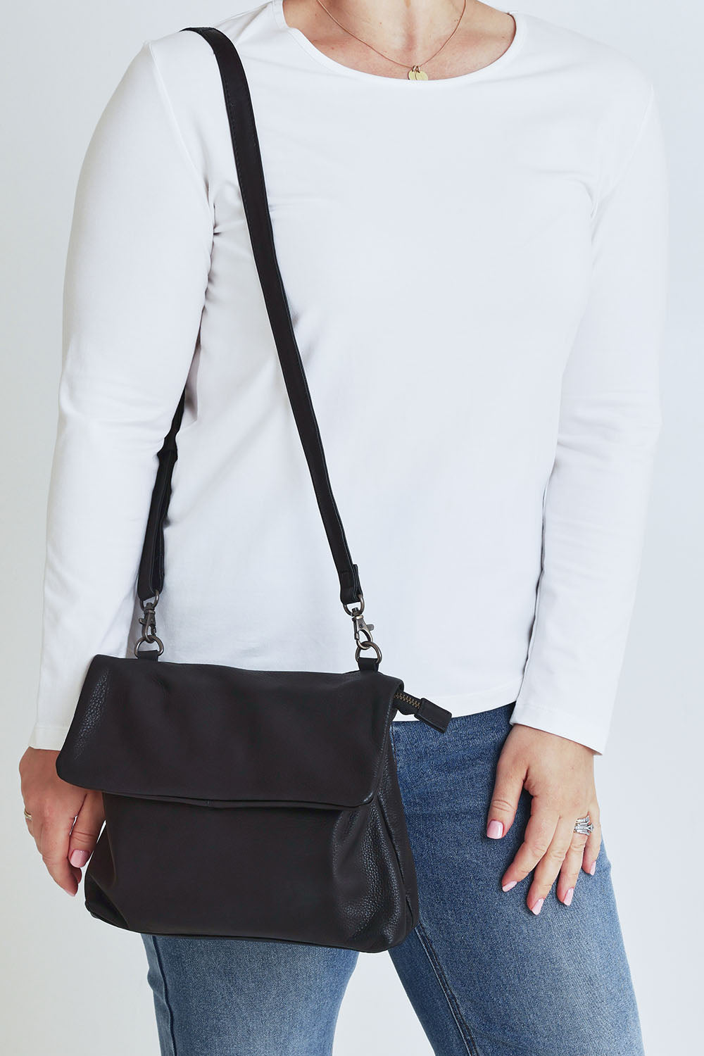 Model Steph wearing size OneSize of the Delphi Leather Bag in colour Black (Black), from the front, cropped image