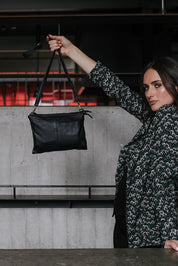 A model wearing the Ellie Leather Bag in colour Black (Black), from the front, showing the whole outfit