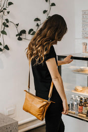 A model wearing the Ellie Leather Bag in colour Tan, from the front, showing the whole outfit
