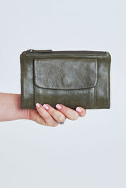 Model Steph wearing size OneSize of the Frankie Leather Wallet in colour Olive (Green), from the front, cropped image