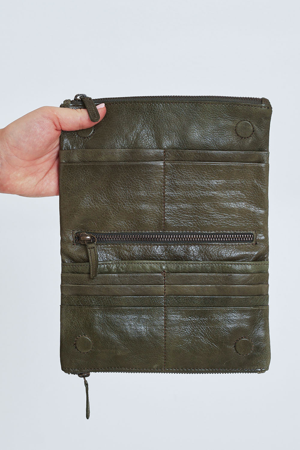 Model Steph wearing size OneSize of the Frankie Leather Wallet in colour Olive (Green), from the front, cropped image