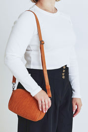Model Steph wearing size OneSize of the Head In The Clouds Leather Bag in colour Tan, from the front, cropped image