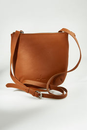 A model wearing the Isabella Crossbody Leather Bag in colour Tan, from the front, showing the whole outfit