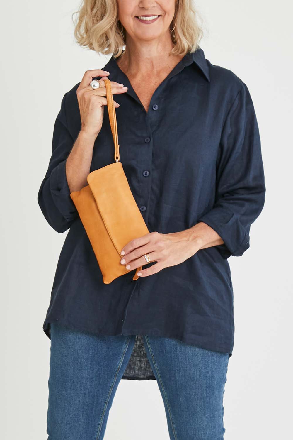 Model Sandy wearing size OneSize of the Lucie Leather Clutch Bag in colour Tan, from the front, cropped image