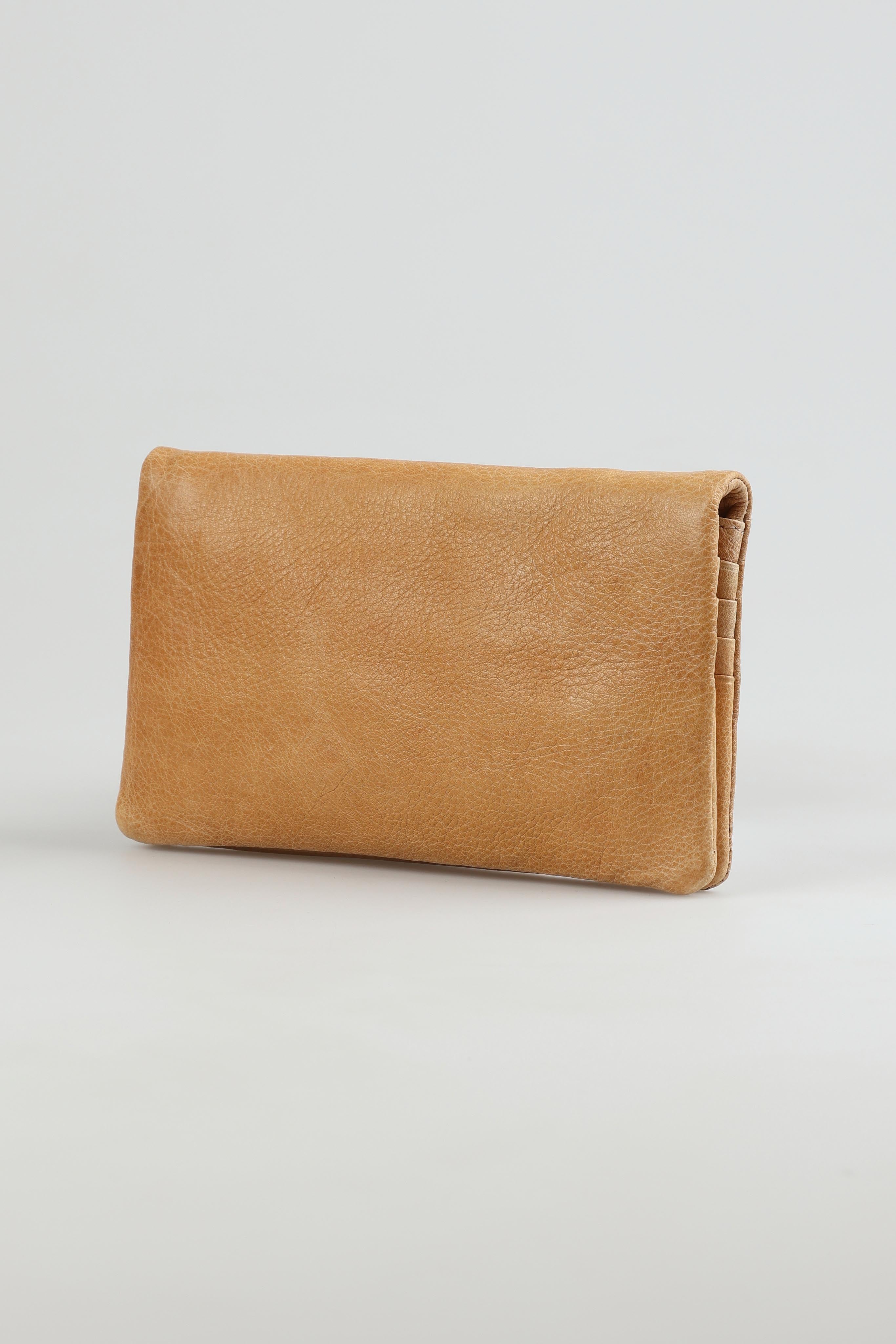 A model wearing the Mila Leather Foldover Purse in colour Sand, from the front, showing the whole outfit