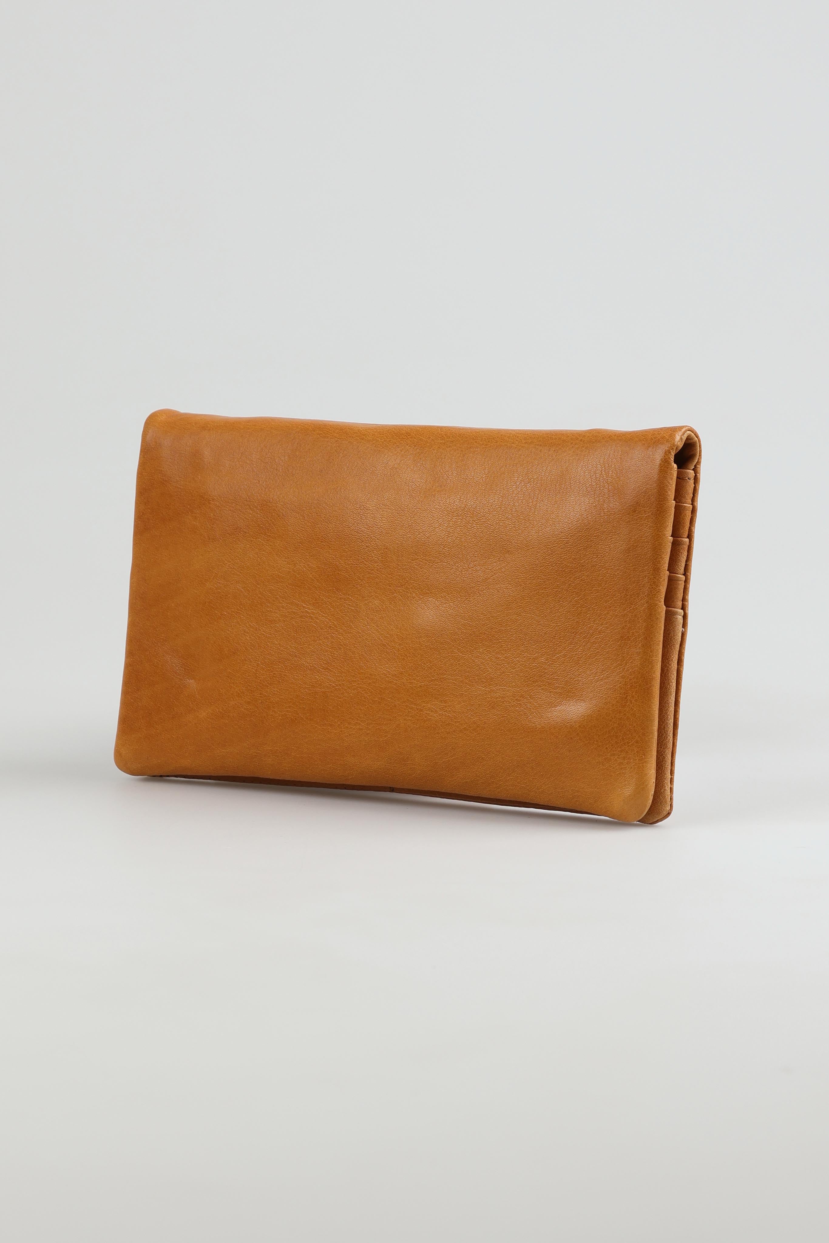 A model wearing the Mila Leather Foldover Purse in colour Tan, from the front, showing the whole outfit