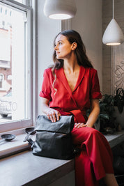 A model wearing the Neve Leather Backpack in colour Black (Black), from the front, showing the whole outfit