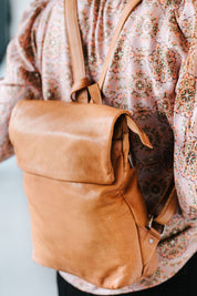 A model wearing the Neve Leather Backpack in colour Tan, from the front, showing the whole outfit