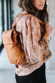 A model wearing the Neve Leather Backpack in colour Tan, from the front, showing the whole outfit