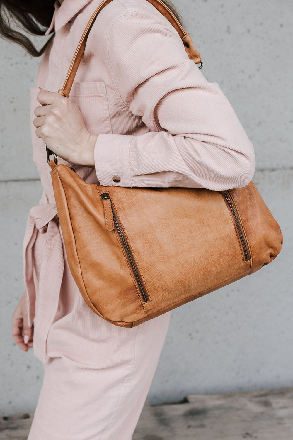 A model wearing the Poppy Leather Bag in colour Tan, from the front, showing the whole outfit