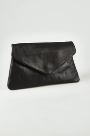 A model wearing the Riley Leather Clutch in colour Black (Black), from the front, showing the whole outfit