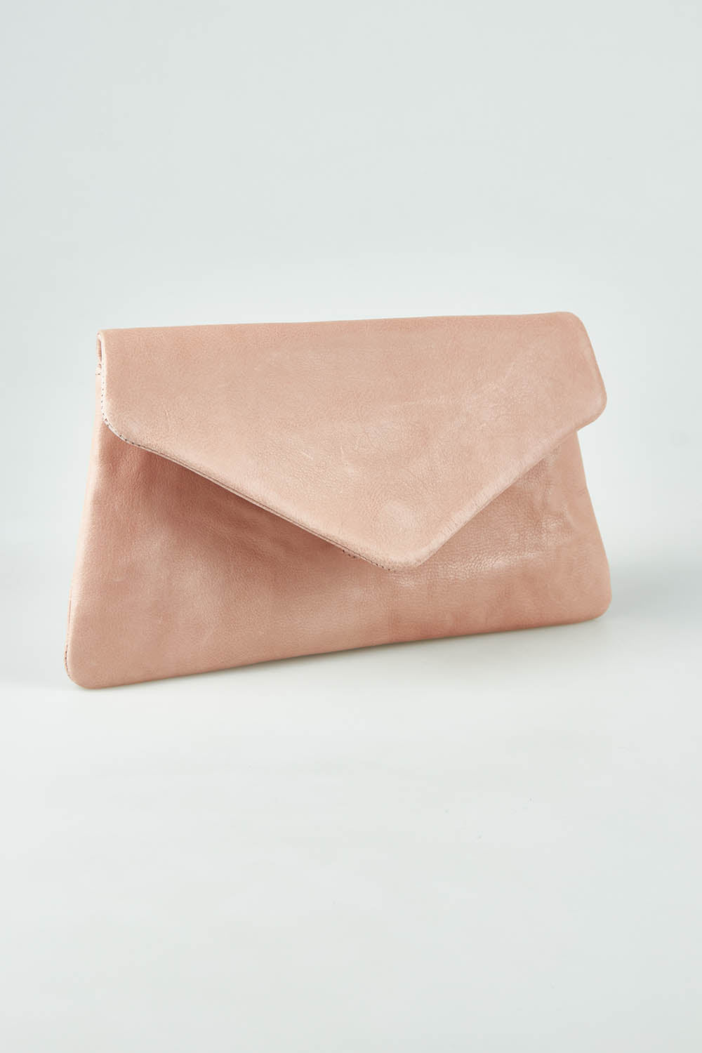 A model wearing the Riley Leather Clutch in colour Duskypink (Pink), from the front, showing the whole outfit