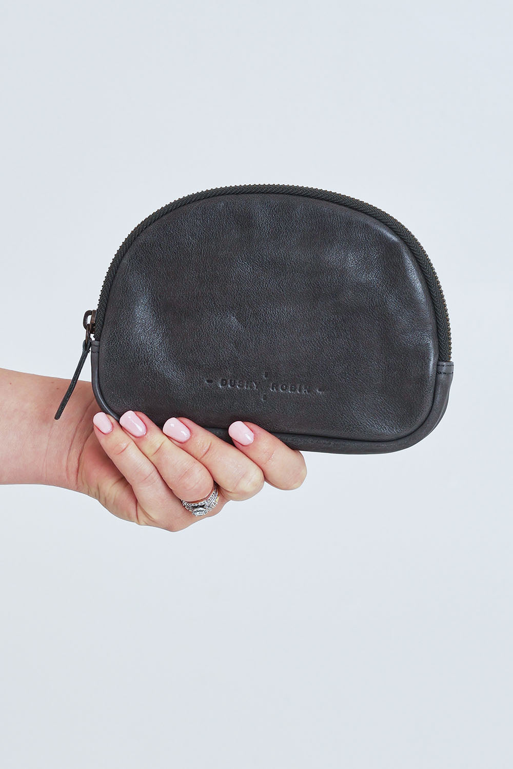 Model Steph wearing the Romi Leather Clutch in colour Charcoal (Grey), from the front, cropped image