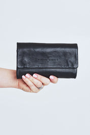 Model Steph wearing size OneSize of the Rose Leather Purse in colour Black (Black), from the front, cropped image