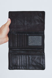 Model Steph wearing size OneSize of the Rose Leather Purse in colour Black (Black), from the front, cropped image