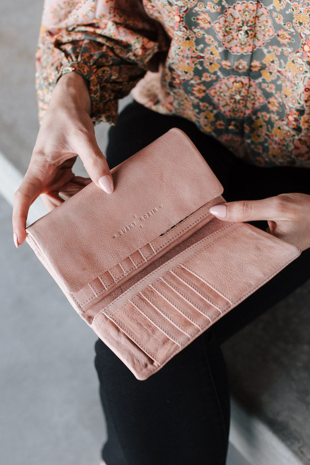 A model wearing the Rose Leather Purse in colour Duskypink (Pink), from the front, showing the whole outfit