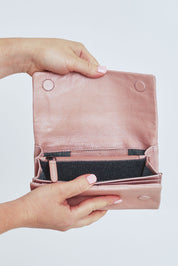 Model Steph wearing size OneSize of the Rose Leather Purse in colour Duskypink (Pink), from the front, cropped image