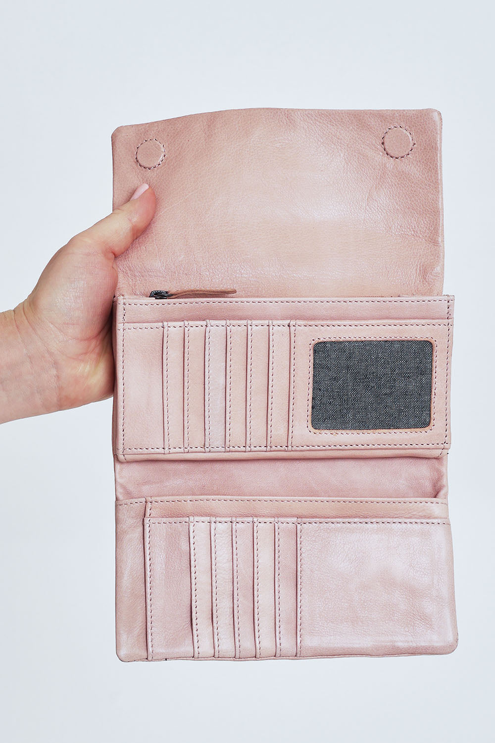 Model Steph wearing size OneSize of the Rose Leather Purse in colour Duskypink (Pink), from the front, cropped image