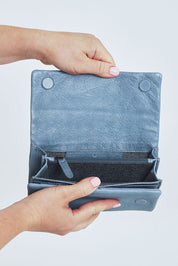 Model Steph wearing size OneSize of the Rose Leather Purse in colour Steelgrey (Grey), from the front, cropped image