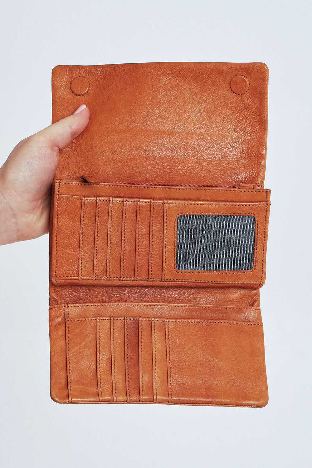 Model Steph wearing size OneSize of the Rose Leather Purse in colour Tan, from the front, cropped image